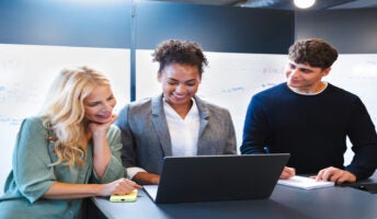 Three colleagues around a laptop. Source: Tech.co