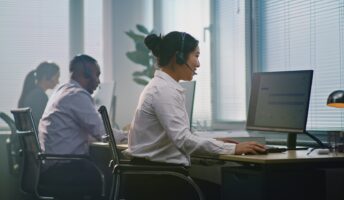 People working in an office, talking on headsets