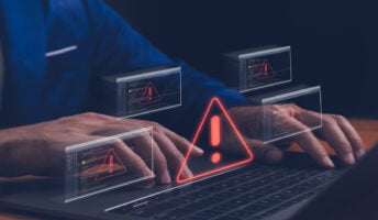 Person working on laptop with data breach on screen