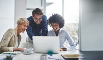 People working around a laptop