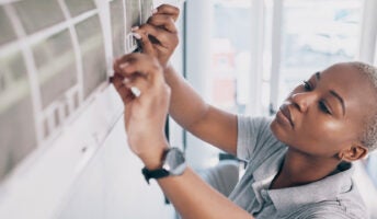 Female technician repairing air conditioning unit illustrating HVAC services