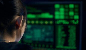 Cyberhacker looks at green text on a computer