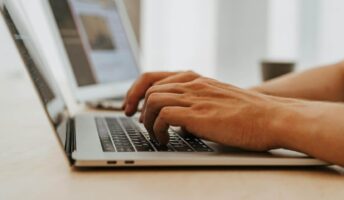 Hands typing on a Mac