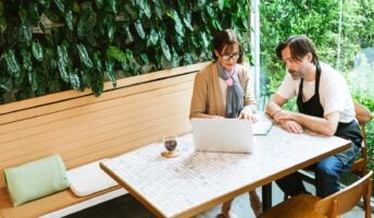 hospitality staff sitting at table working at computer