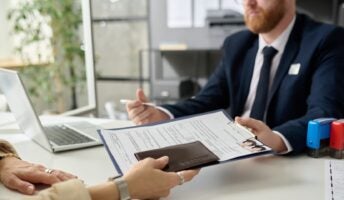 Woman being handed visa application by US officer
