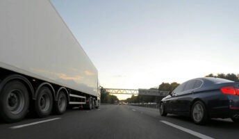 A truck on a road with a car